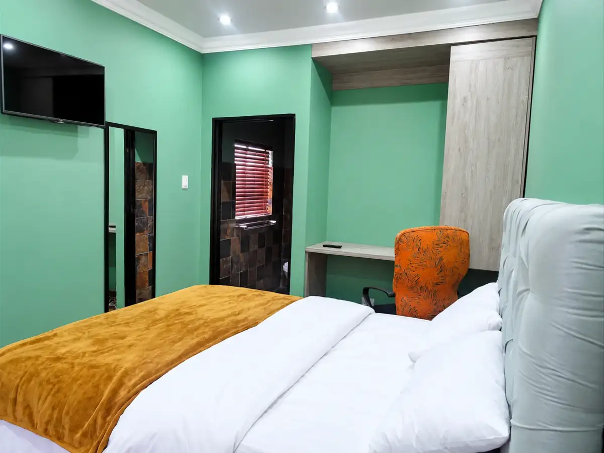 Guest room with television, desk and private bathroom entrance