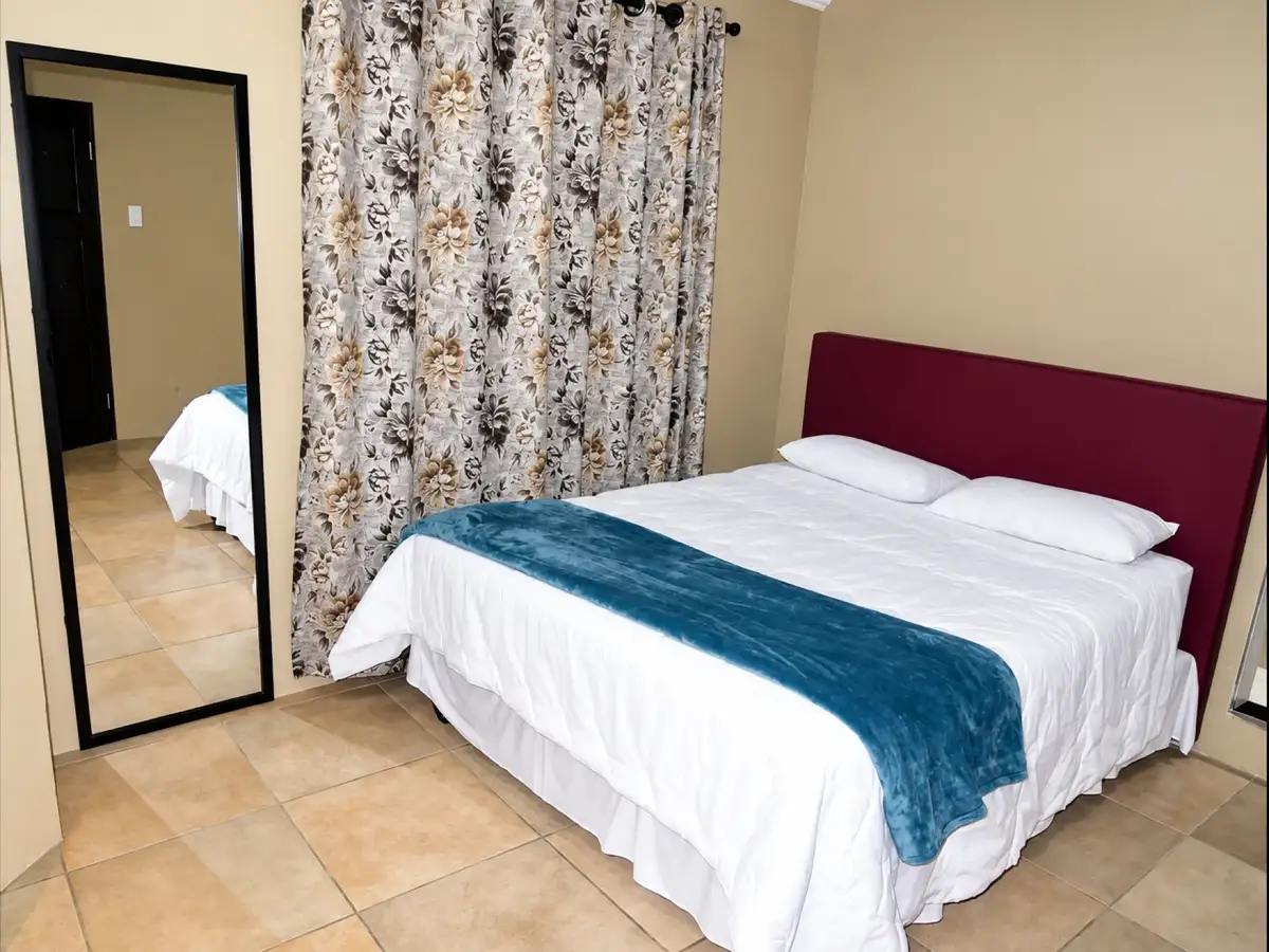 Guest room with blue throw and full-length mirror