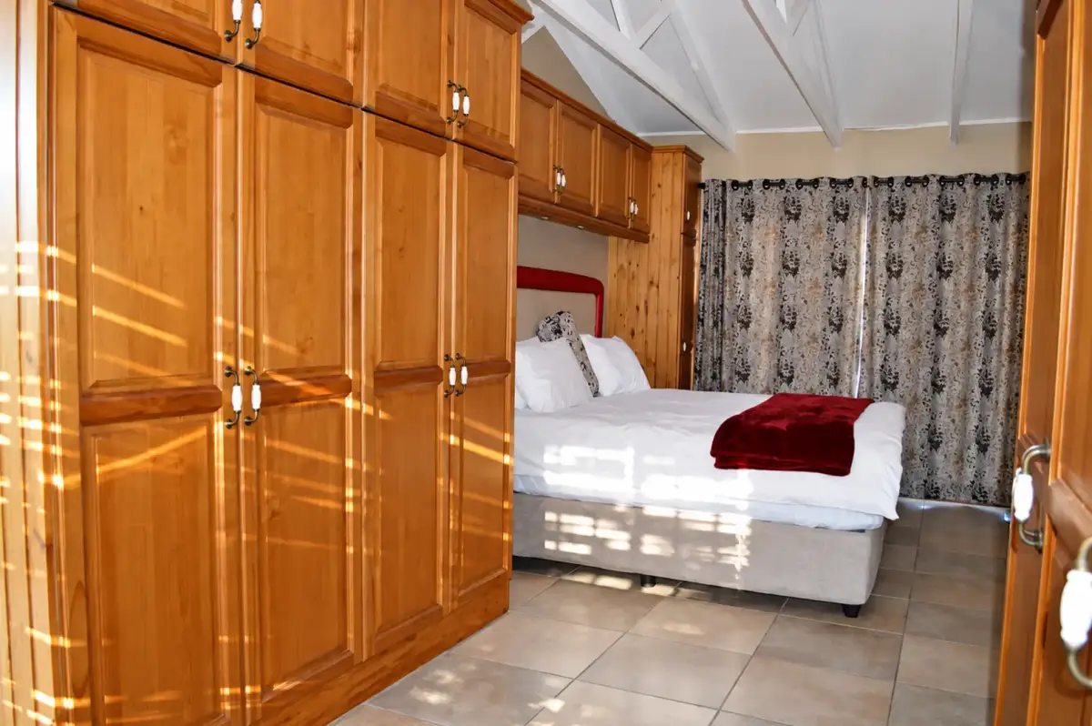 Guest room with timber cupboards and white bedding